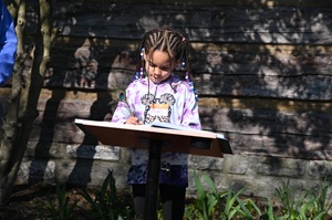 Girl signing the Book of Readers